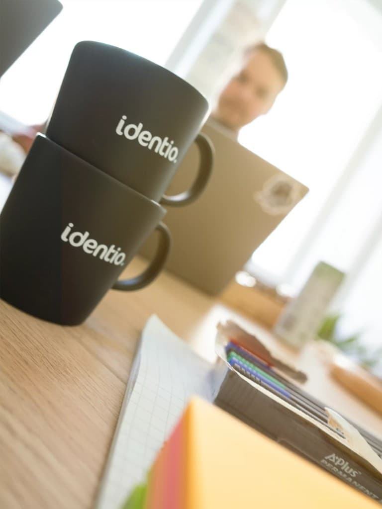 Identio coffee cup on a table with two people sitting in the background